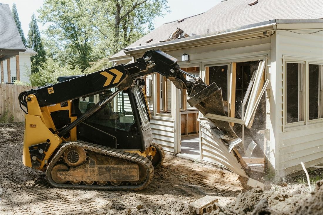 Machinery clearing an existing house to prepare the site for a new build